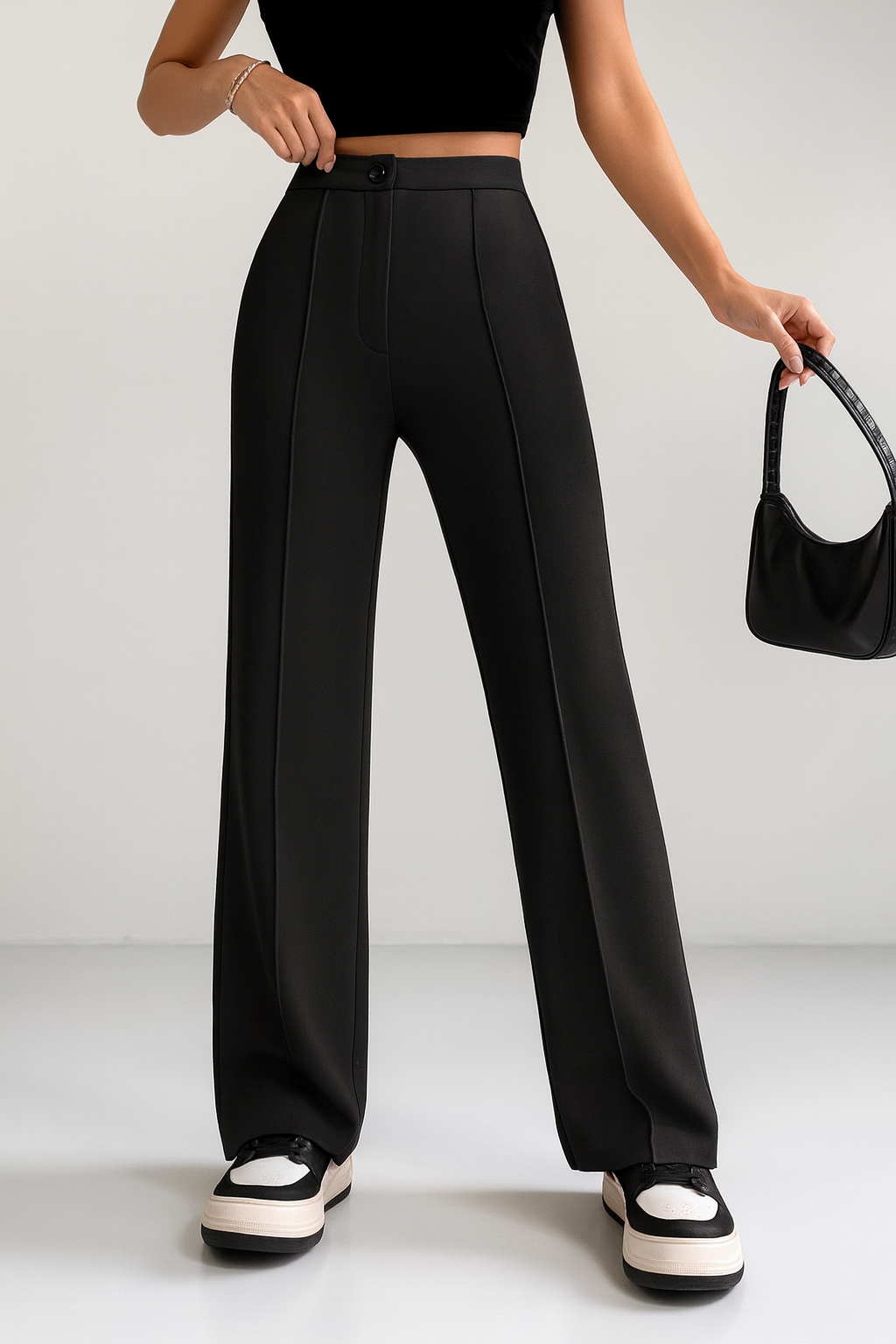 Woman wearing black pants standing against white background